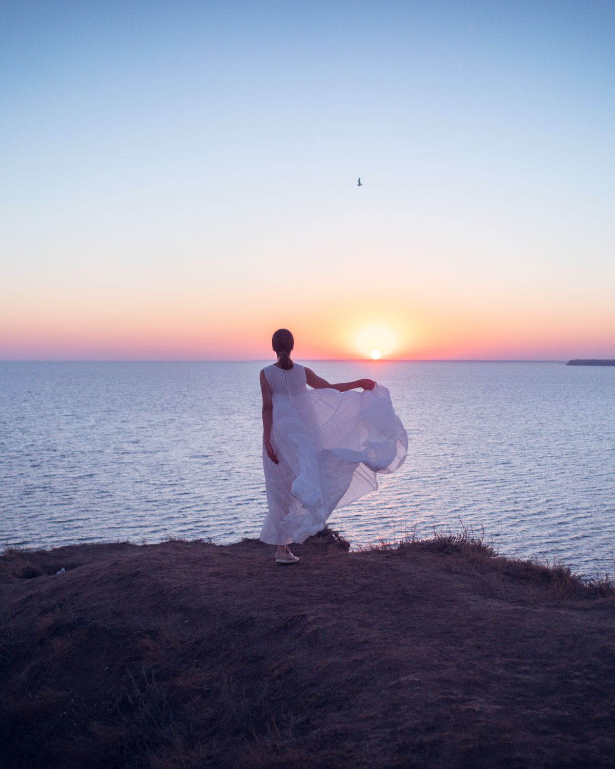 Mujer serena mirando el atardecer sobre el mar